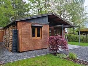 une petite maison avec un extérieur en bois dans l'établissement Le Cha'let Resteigne, à Wellin