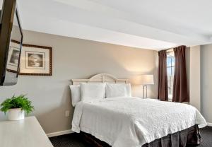 um quarto com uma cama branca e uma janela em Sea Rose Suites em Ogunquit