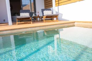 two chairs sitting next to a swimming pool at Orsalia villa wellness in Poros