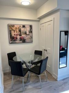 una sala da pranzo con tavolo in vetro e sedie di Lovely one bedroom condo with free parking a Niagara Falls