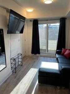 un soggiorno con divano e TV a schermo piatto di Lovely one bedroom condo with free parking a Niagara Falls