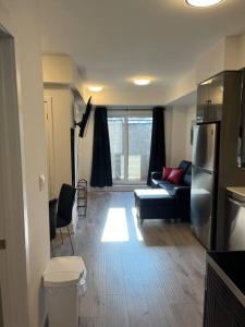 un soggiorno con divano e frigorifero di Lovely one bedroom condo with free parking a Niagara Falls