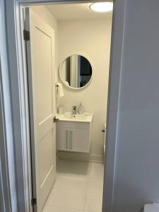 bagno bianco con lavandino e specchio di Lovely one bedroom condo with free parking a Niagara Falls