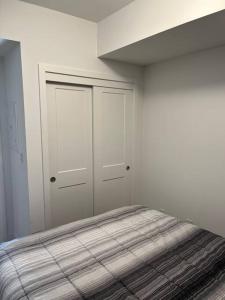 Camera bianca con letto e armadio di Lovely one bedroom condo with free parking a Niagara Falls