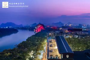 Blick auf einen Fluss und eine Stadt in der Nacht in der Unterkunft Riverside Wing Hotel Guilin in Guilin