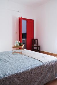 - une chambre avec un grand lit et une porte rouge dans l'établissement Além Tejo Guesthouse, à Mértola