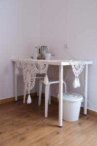 - une table blanche avec des rideaux en dentelle dans l'établissement Além Tejo Guesthouse, à Mértola