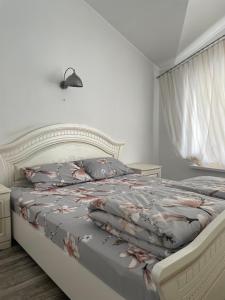 Un dormitorio blanco con una cama con flores. en Comfort place in the city centre, en Ivano-Frankivsk