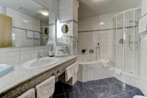 bagno con lavandino, doccia e vasca di Wellnesshotel Hofbräuhaus a Bodenmais