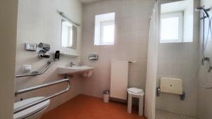 a white bathroom with a sink and a shower at Hotel Kindler 2,0 Self-Check-In in Leoben