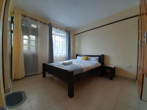 um quarto com uma cama e uma grande janela em Milimani Nanyuki em Nanyuki