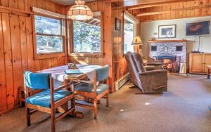 a dining room with a table and chairs and a fireplace at McGregor Mountain Lodge in Estes Park