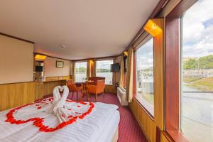 um quarto com uma cama e uma mesa com vista em Fortuna Boat Hotel Budapest em Budapeste