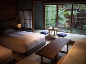 una camera da letto con un letto e un tavolo e una grande finestra di HOTEL VMG RESORT KYOTO a Kyoto