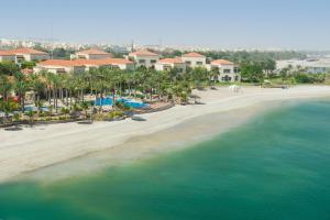 een luchtzicht op een strand met palmbomen en huizen bij Al Raha Beach Hotel in Abu Dhabi