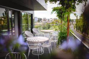 un gruppo di tavoli e sedie su un balcone di My Story Gdynia Hotel a Gdynia