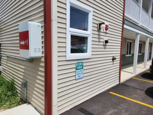 une maison avec une fenêtre et un panneau sur celle-ci dans l'établissement Driftwood Motel, à Niagara Falls