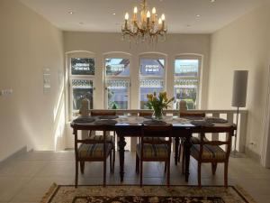 a dining room with a table with chairs and a chandelier at Villa Klara Cieplice in Jelenia Góra