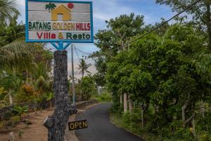 um sinal para um edifício chamado Bowling Garden Hills Village e Resgate em Batang Golden Hills em Nusa Penida