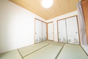 een lege kamer met grote ramen en een plafond bij NY Cottage（コテージ） in Tokyo