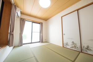 een lege kamer met een groot raam bij NY Cottage（コテージ） in Tokyo