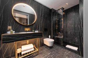 a black bathroom with a sink and a mirror at No.4 Carlton in Southampton