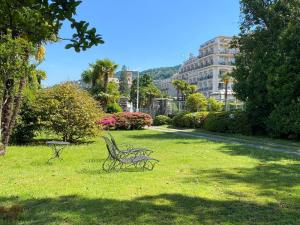 un parque con dos bancos en el césped en Wonderful Stresa apartment, en Stresa