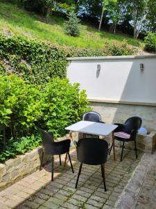 een tafel en stoelen op een bakstenen patio bij Maison face à l'abbaye d'Hautvillers - 2 bedrooms 2 Bathrooms, parking in Hautvillers