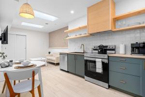 una cucina con armadi blu e tavolo e una cucina con divano di The Olympia: Front Street Flats a Belleville