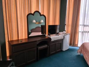 een slaapkamer met een bureau en een spiegel bij Glorieta Hotel in Sucre