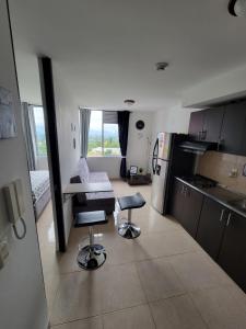 a kitchen with two stools in the middle of a room at Comodo Apartaestudio al Norte de Armenia, con Parqueadero de Carro, en la salida a Salento y Filandia! in Armenia