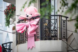 un ours en peluche rose assis sur un balcon avec une arche rose dans l'établissement The Yangtze Boutique Shanghai, à Shanghai