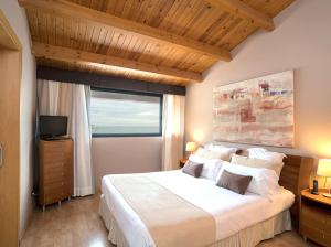 a bedroom with a large white bed and a window at Estela Barcelona in Sitges