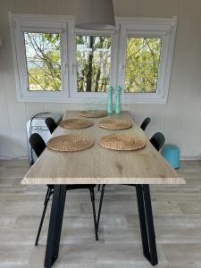 uma mesa de madeira com quatro cadeiras e duas janelas em Kite House Chałupy em Władysławowo