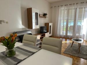 a living room with a table and chairs and a television at Apartmani Roko in Biograd na Moru