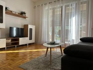 a living room with a couch and a tv and a table at Apartmani Roko in Biograd na Moru