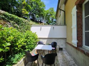 een tafel en stoelen aan de zijkant van een gebouw bij Maison face à l'abbaye d'Hautvillers - 2 bedrooms 2 Bathrooms, parking in Hautvillers