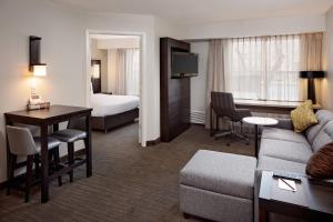 een hotelkamer met een bank, een tafel en een bed bij Residence Inn Arlington in Arlington