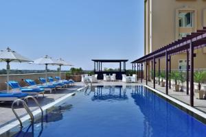 een zwembad van het hotel met stoelen en parasols bij Fairfield by Marriott Amritsar in Amritsar