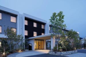 un edificio blanco y negro con árboles delante en Fairfield by Marriott Mie Okuise Odai, en Odaicho