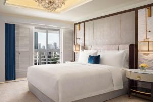 1 dormitorio con 1 cama blanca grande y ventana grande en The St. Regis Jakarta en Yakarta