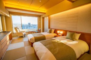 a hotel room with two beds and a window at Dogo Prince Hotel in Matsuyama