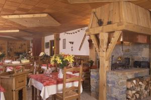 une salle à manger avec une table et une cheminée en pierre dans l'établissement Edelweiss, à Samoëns