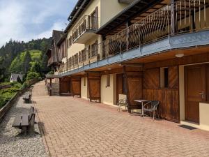 a building with a patio with tables and chairs at La source in Sondernach