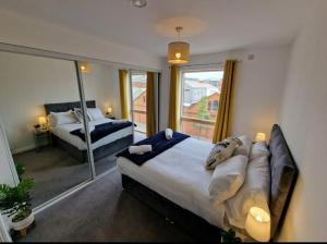 - une chambre avec 2 lits et une grande fenêtre dans l'établissement Modern apartment, sleeps 6, Belfast city centre, à Belfast