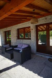 a patio with two chairs under a wooden roof at Rilhadas Casas de Campo in Fafe