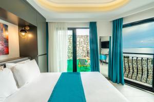 Gumus Peninsula Hotel في كاس: غرفه فندقيه بسرير وشرفه