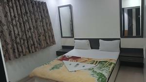 una piccola camera con letto e specchio di Hotel Shree Sai Darshan a Shirdi