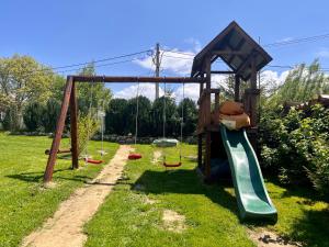 um parque infantil com escorrega e um ursinho de peluche. em Casa Cenţiu em Bran