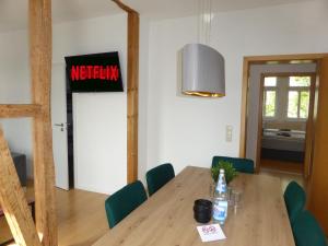 una sala da pranzo con tavolo in legno e sedie verdi di Jena City Apartment, Balkon, sonnig, Wifi, Parkplätze, Nähe Zentrum a Jena